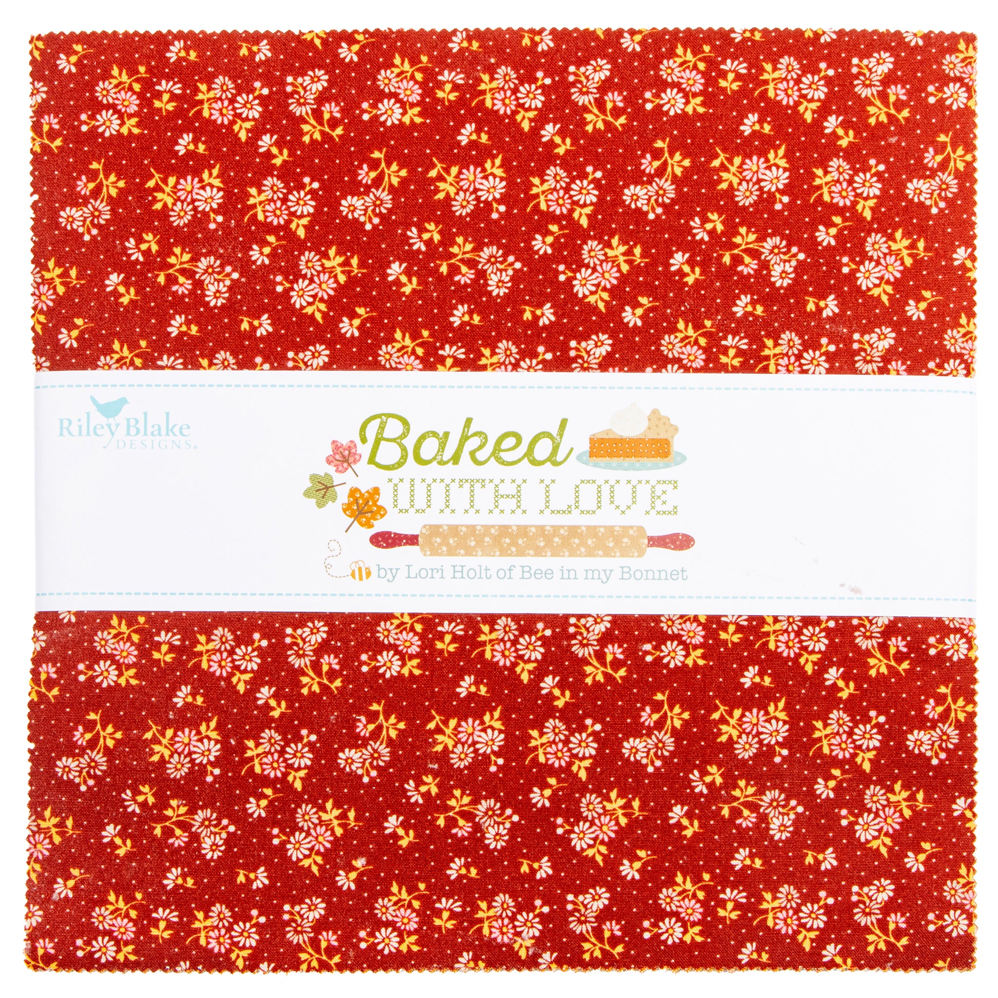A folded fabric bundle with a red background and a white center band printed with the text 'Baked WITH LOVE' and 'by Lori Hall of Bew in my Beecher.' The fabric has a repeating floral and leaf pattern in yellow, orange, and white.