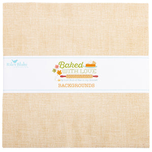 A square fabric or paper background product by Riley Blake Designs, shown folded with a white paper band across the middle. The material has a warm beige linen-like texture, and the band reads 'Baked with Love' and 'BACKGROUND' with small baking-themed illustrations.