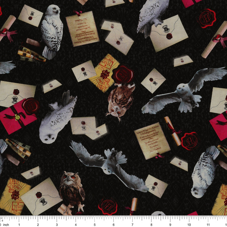White and brown owls, sealed letters, scrolls and books on black Harry Potter fabric with subtle scrollwork with ruler for scale.