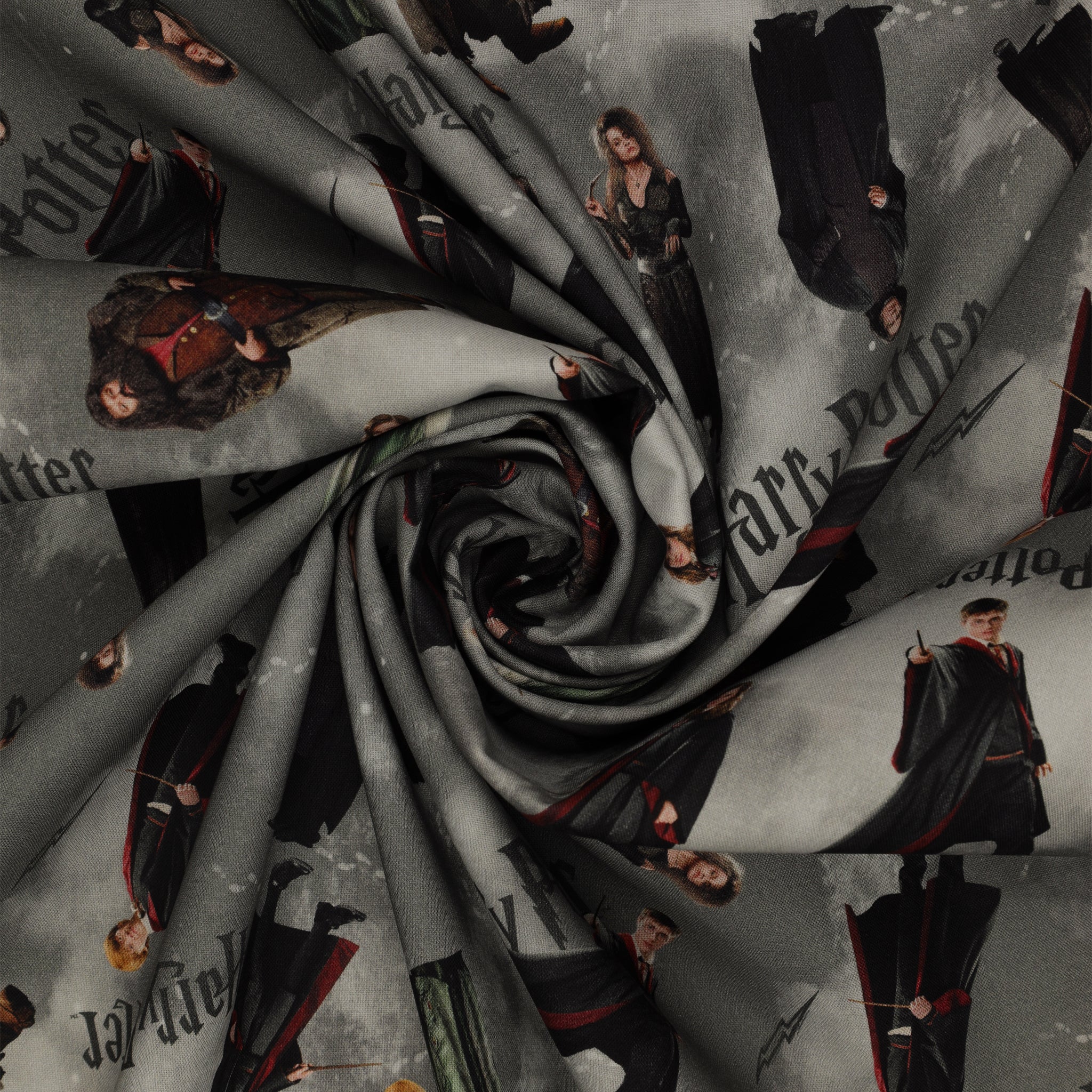 Gray Harry Potter fabric with scattered robed film figures, black logos, lightning bolts and pale footprints in a swirl.