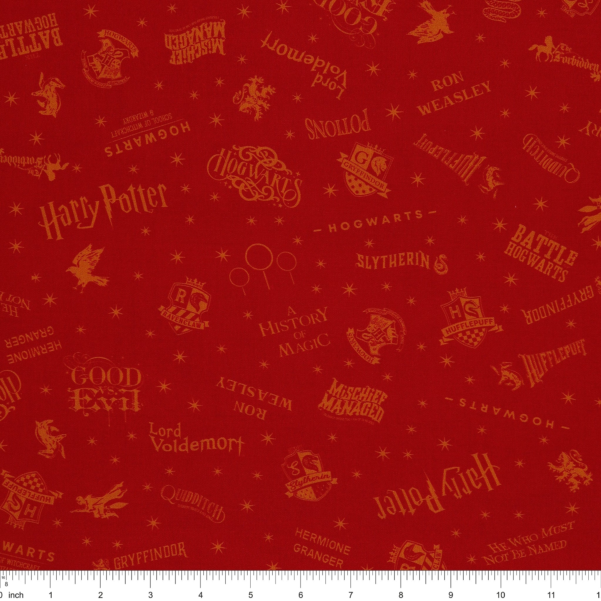 Red Harry Potter fabric with golden-yellow lettering, Hogwarts house shields and scattered stars with ruler for scale.