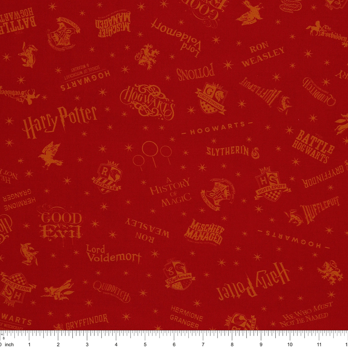 Red Harry Potter fabric with golden-yellow lettering, Hogwarts house shields and scattered stars with ruler for scale.