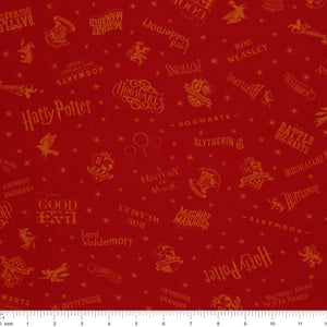 Red Harry Potter fabric with golden-yellow lettering, Hogwarts house shields and scattered stars with ruler for scale.