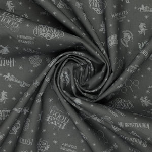 Charcoal Harry Potter fabric with pale gray words, house crests, Quidditch goalposts and stars in a swirl.