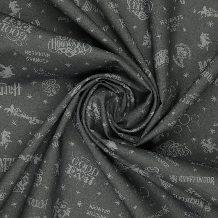 Charcoal Harry Potter fabric with pale gray words, house crests, Quidditch goalposts and stars in a swirl.