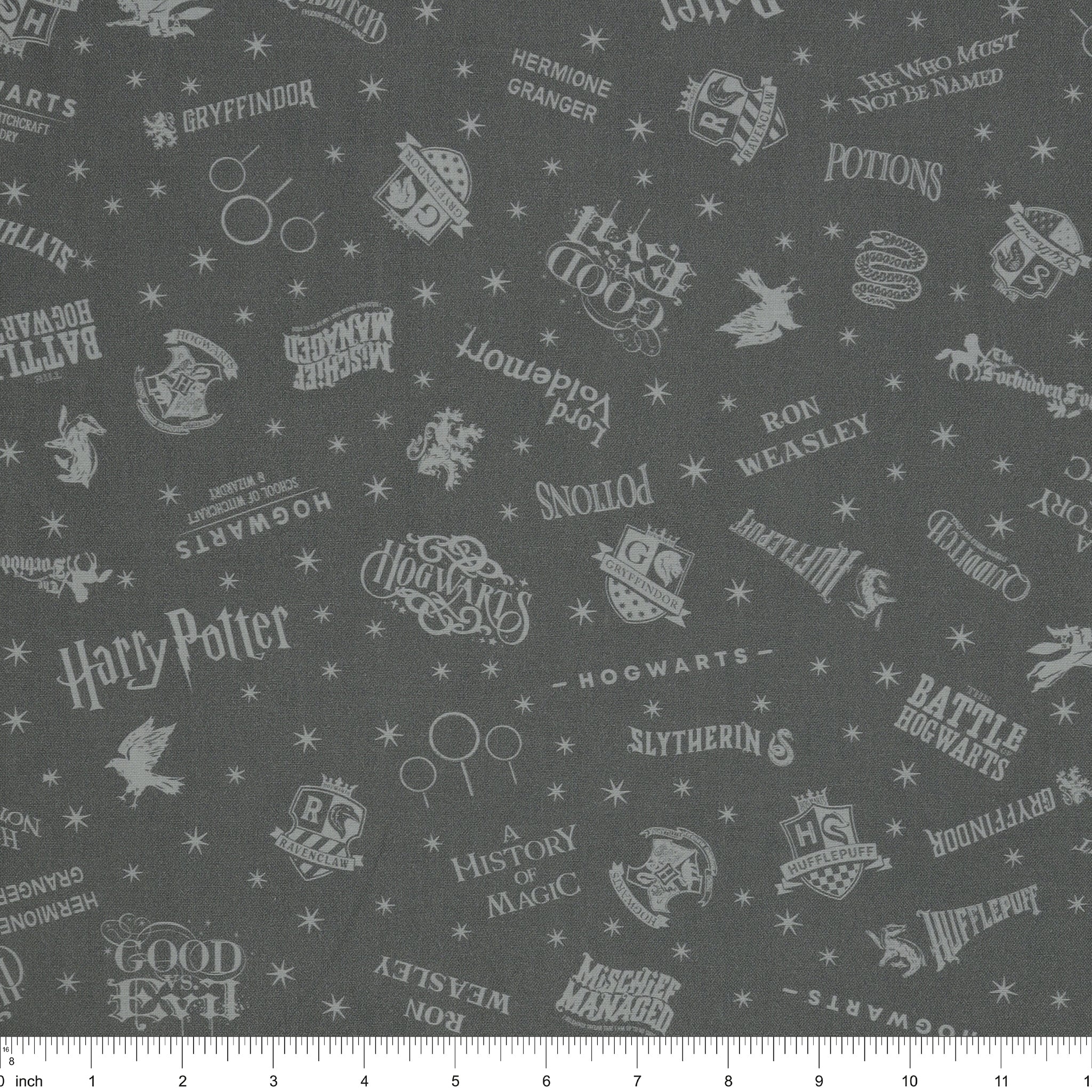 Charcoal Harry Potter fabric with pale gray words, house crests, Quidditch goalposts and stars with ruler for scale.