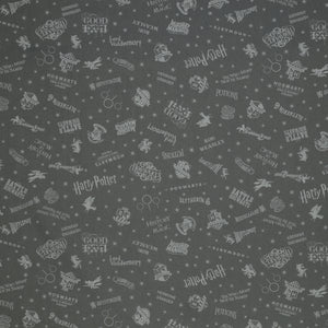 Charcoal Harry Potter fabric with pale gray words, house crests, Quidditch goalposts and stars.