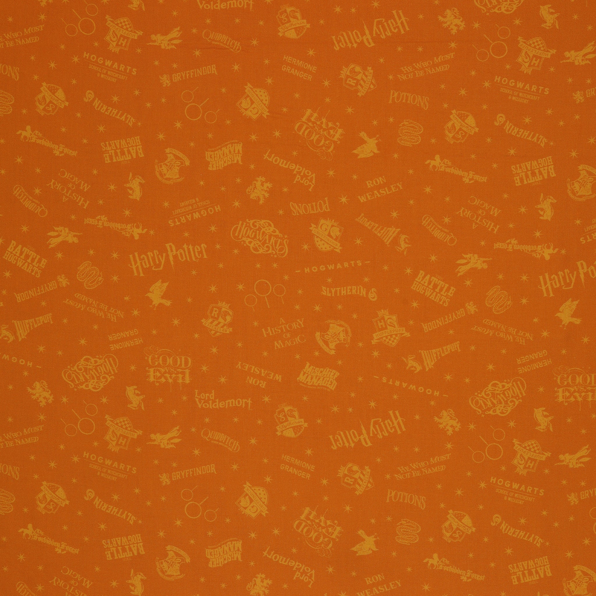 Amber-gold Harry Potter fabric with lighter golden words, house emblems and tiny starbursts.