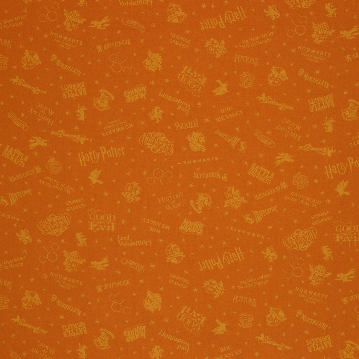 Amber-gold Harry Potter fabric with lighter golden words, house emblems and tiny starbursts.