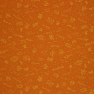 Amber-gold Harry Potter fabric with lighter golden words, house emblems and tiny starbursts.