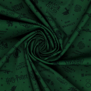 Dark green Harry Potter fabric with nearly black house crests, serpents, words and scattered stars in a swirl.