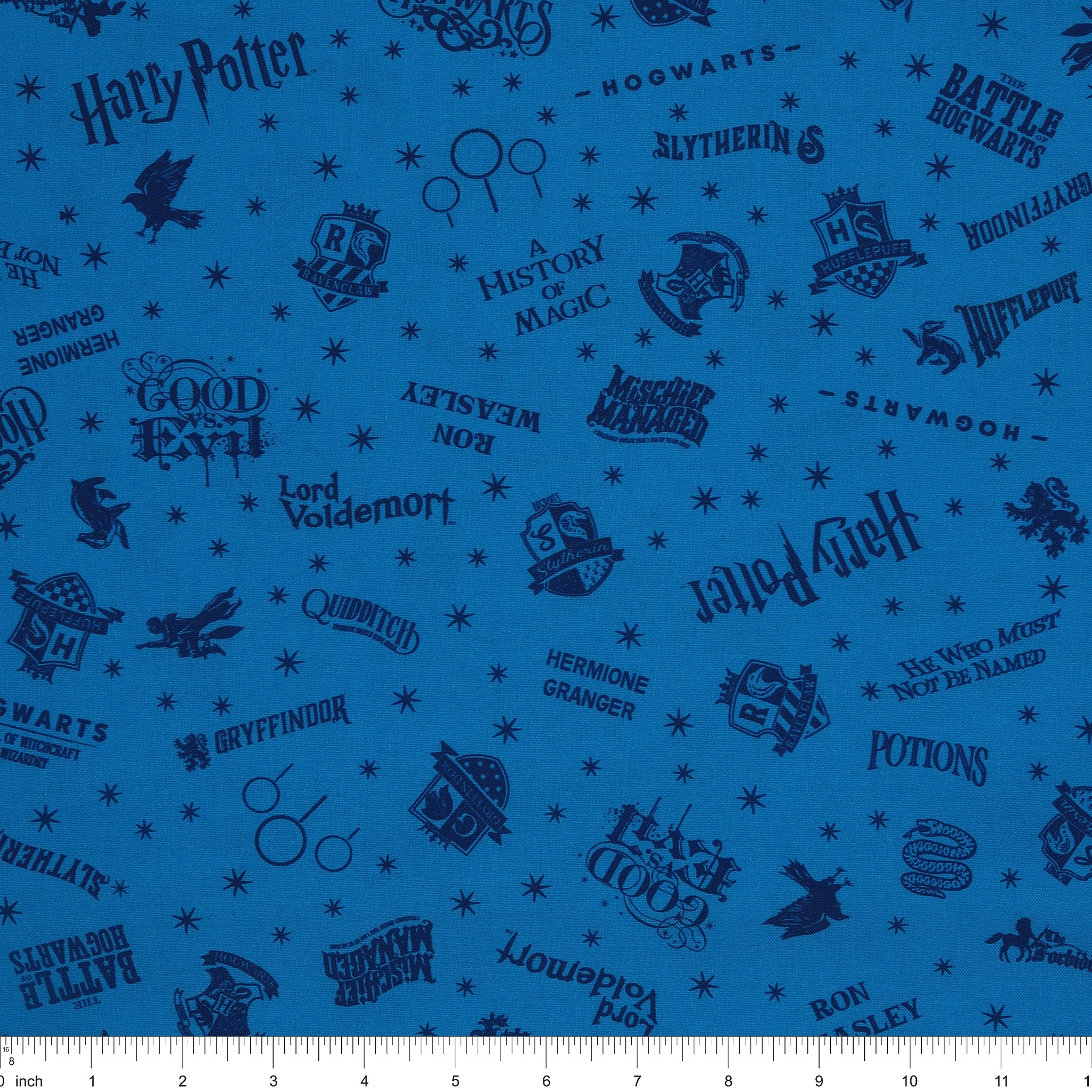 Blue Harry Potter fabric with navy lettering, house badges, Quidditch goalposts and small stars with ruler for scale.