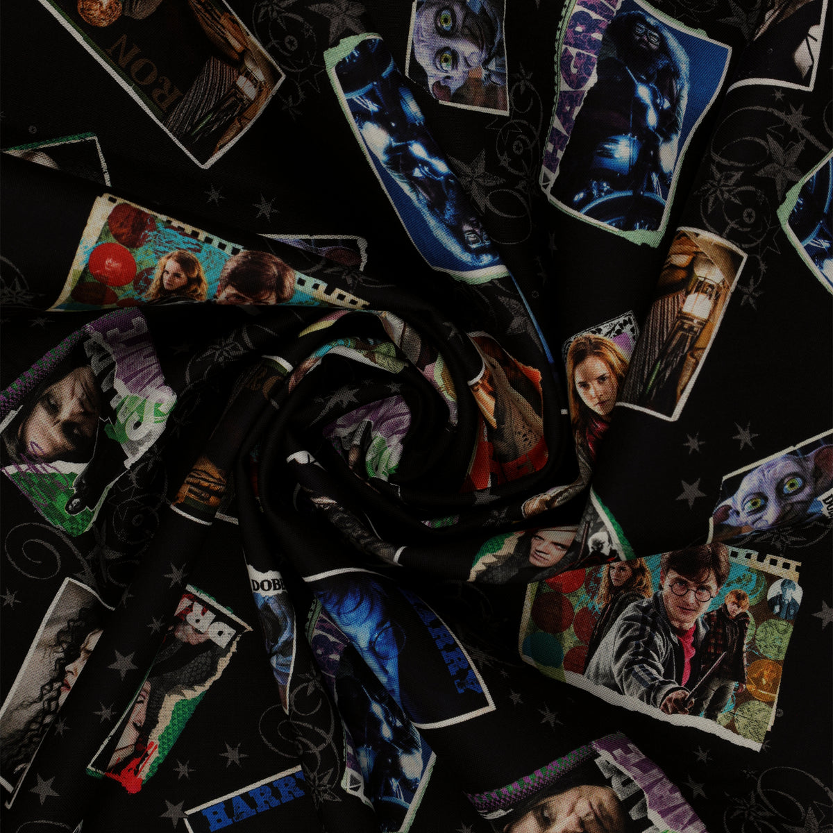 Black Harry Potter fabric with colorful framed film portraits, gray stars and swirling flourishes in a swirl.