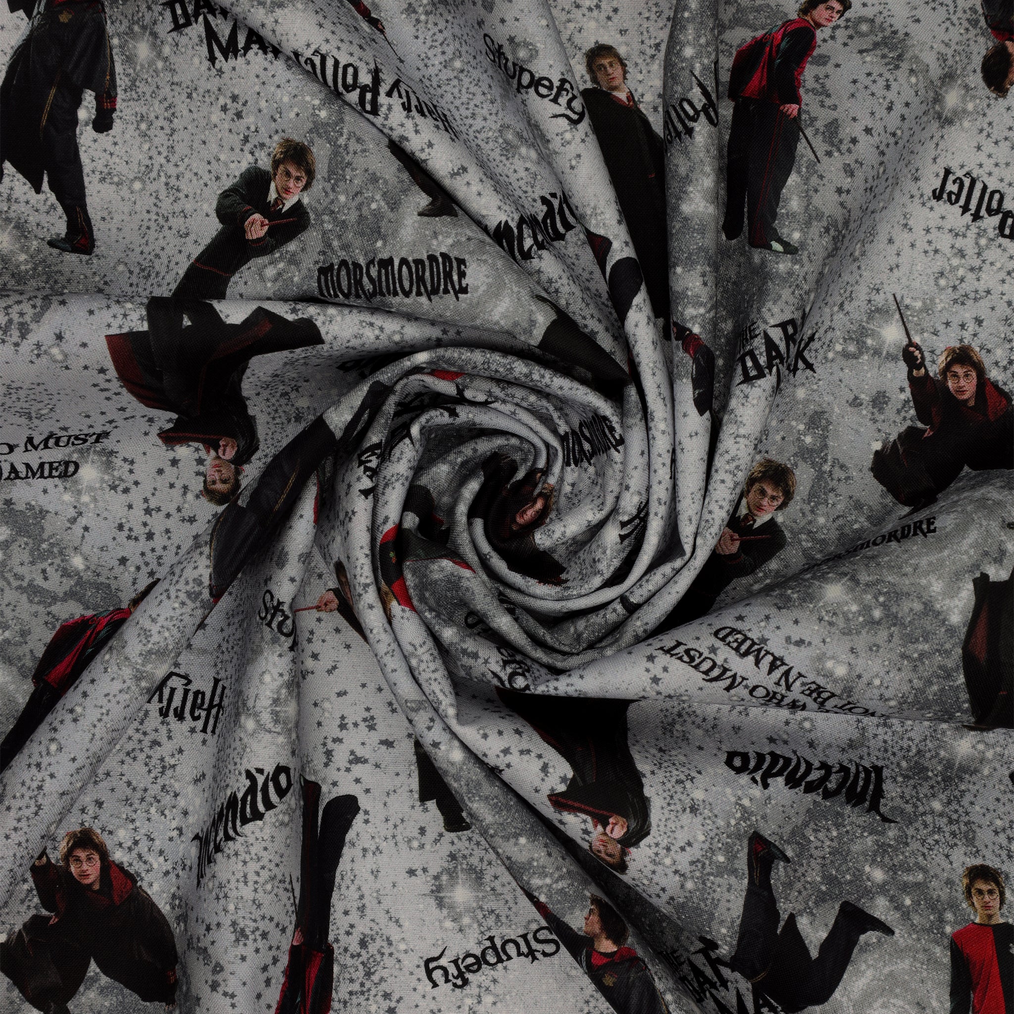 Gray Harry Potter fabric with wand-wielding figures, spell names, stars and smoky swirls in a swirl.