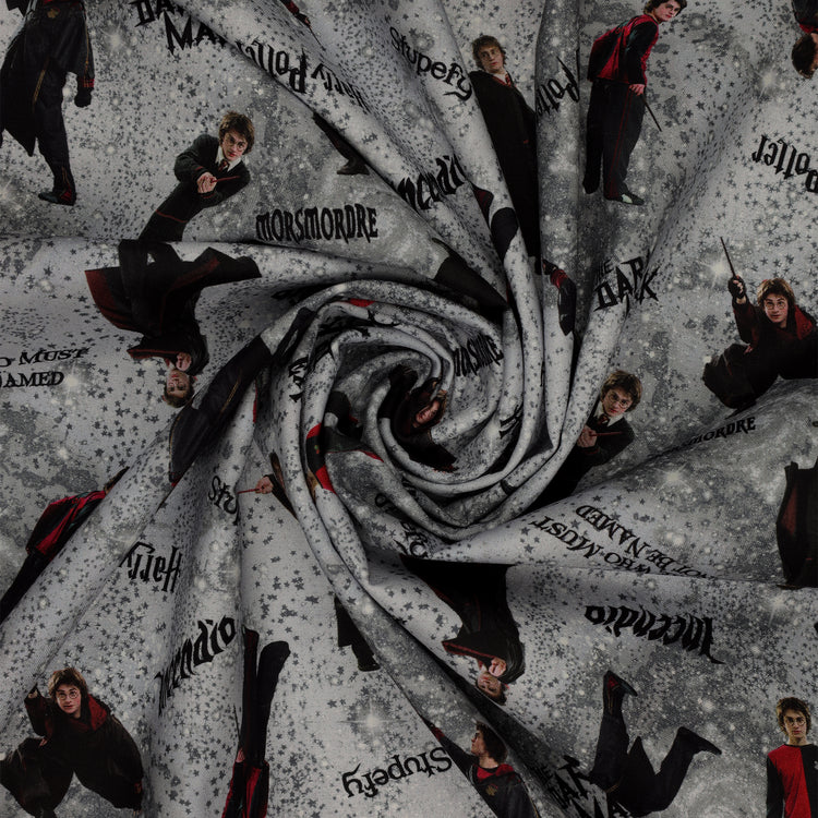 Gray Harry Potter fabric with wand-wielding figures, spell names, stars and smoky swirls in a swirl.