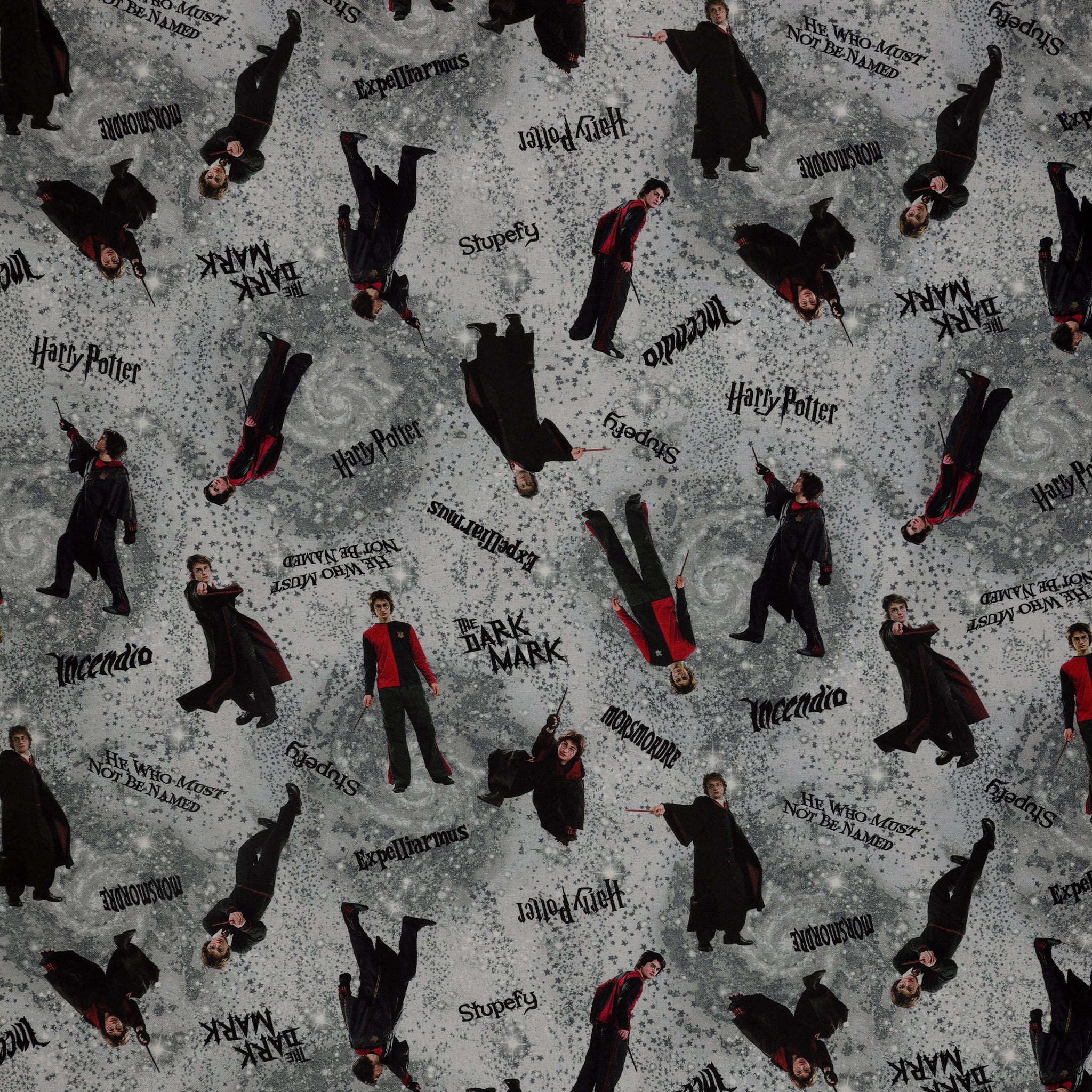 Gray Harry Potter fabric with wand-wielding figures, spell names, stars and smoky swirls.
