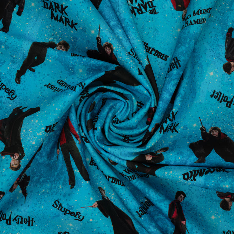 Turquoise Harry Potter fabric with robed figures, black spell lettering and scattered stars over blue swirls arranged in a swirl.