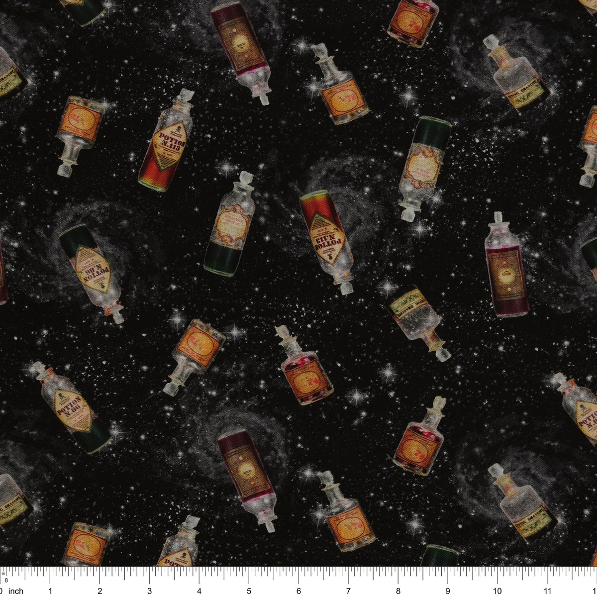 Black Harry Potter fabric with scattered potion bottles, antique-style labels, gray swirls and white stars with ruler for scale.