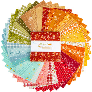 A circular arrangement of patterned fabric squares in many colors, with a central white paper band reading 'Baked With Love.' The fabrics show floral, check, plaid, and solid patterns in red, orange, yellow, green, blue, pink, and beige tones on a white background.