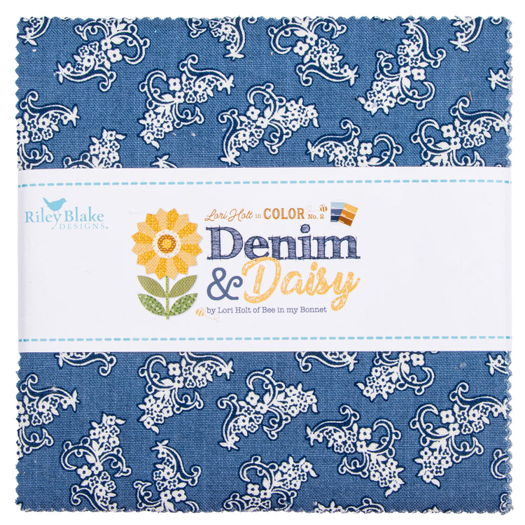 A folded fabric bundle with a blue and white floral paisley pattern, wrapped in a white paper band labeled Riley Blake Designs Denim & Daisy.