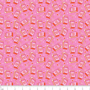 Pink fabric with tossed heart matchboxes and lit matches, shown with ruler for scale