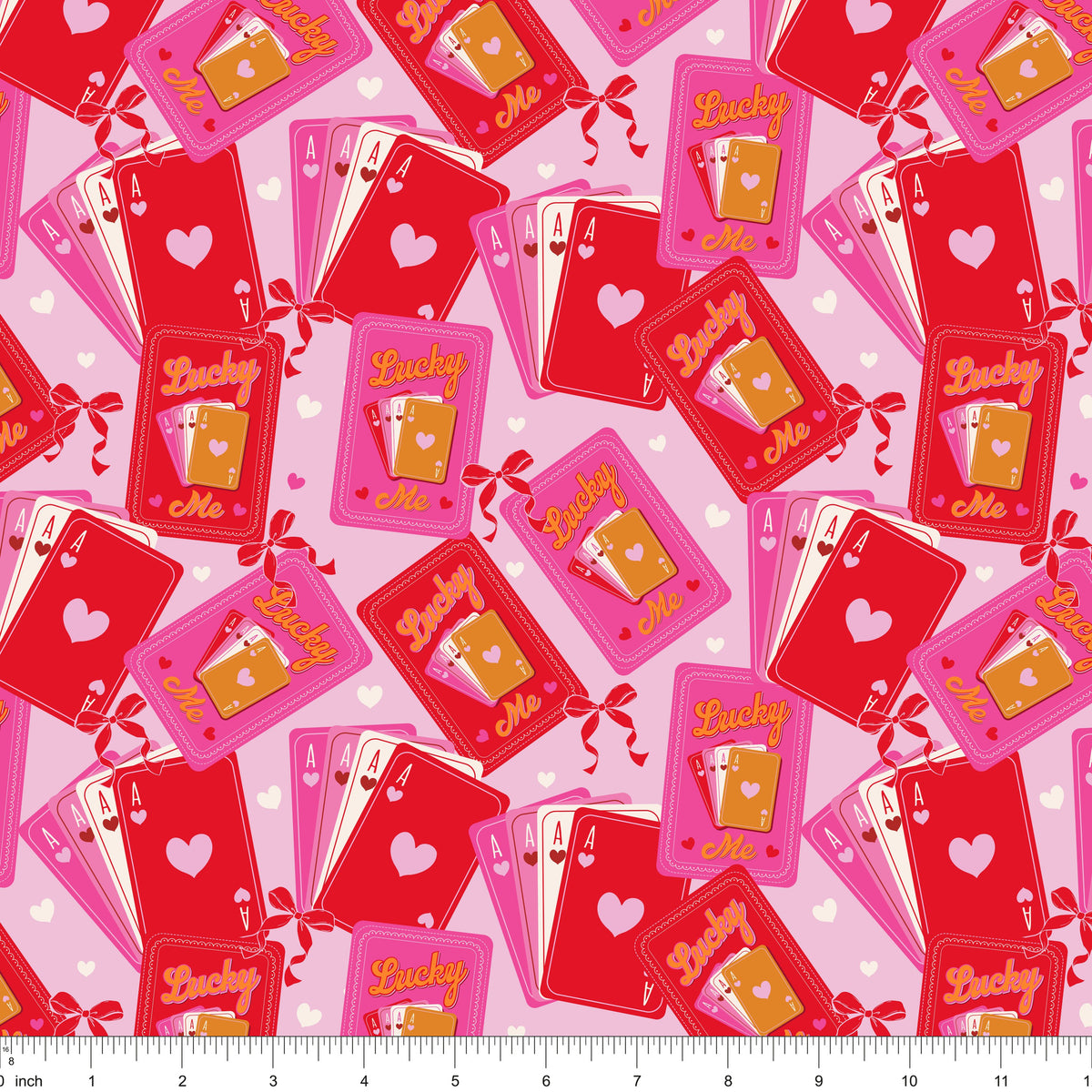 Red and pink fabric with Lucky Me playing cards and aces, shown with ruler for scale