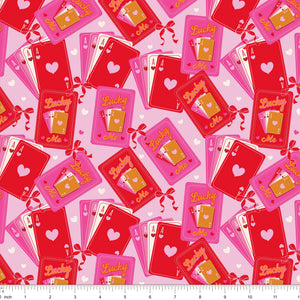 Red and pink fabric with Lucky Me playing cards and aces, shown with ruler for scale