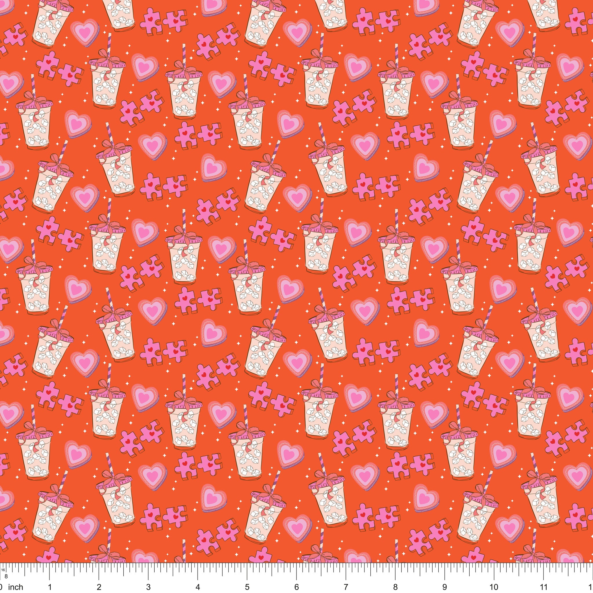 Orange fabric with iced drinks, pink hearts and puzzle pieces, shown with ruler for scale