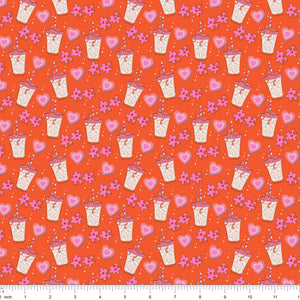 Orange fabric with iced drinks, pink hearts and puzzle pieces, shown with ruler for scale