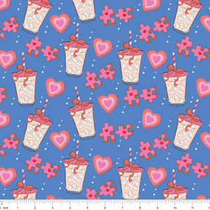 Blue fabric with iced drinks tied with bows, pink hearts and puzzle pieces, shown with ruler for scale