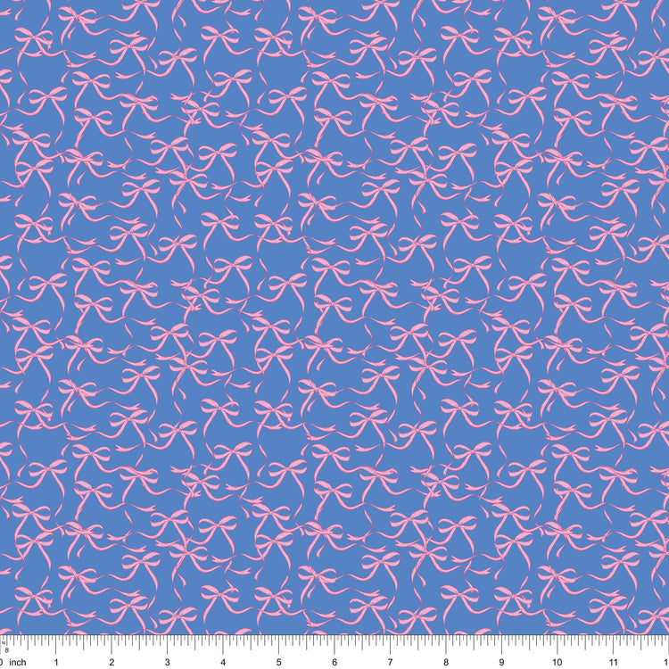 Blue fabric with flowing pink ribbon bows, shown with ruler for scale