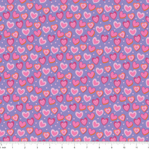 Lavender fabric with layered pink hearts, shown with ruler for scale