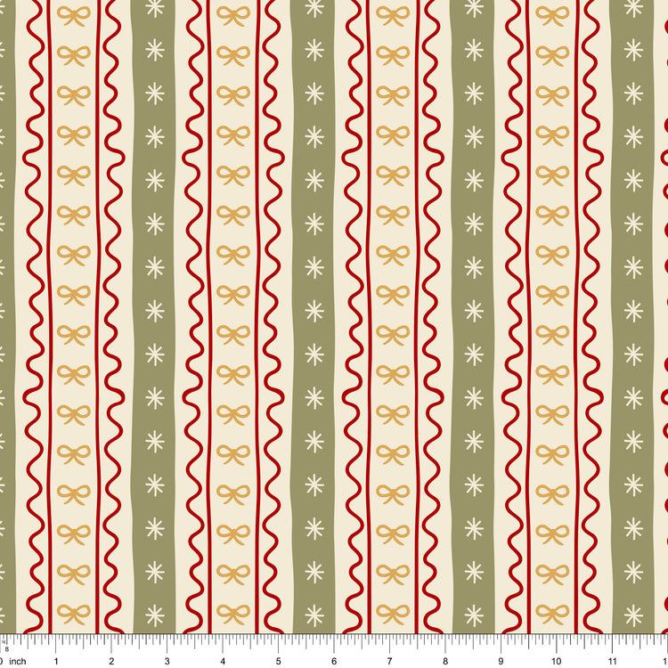 Cream fabric with vertical stripes of red ric rac, gold bows and sage bands with stars, shown with ruler for scale