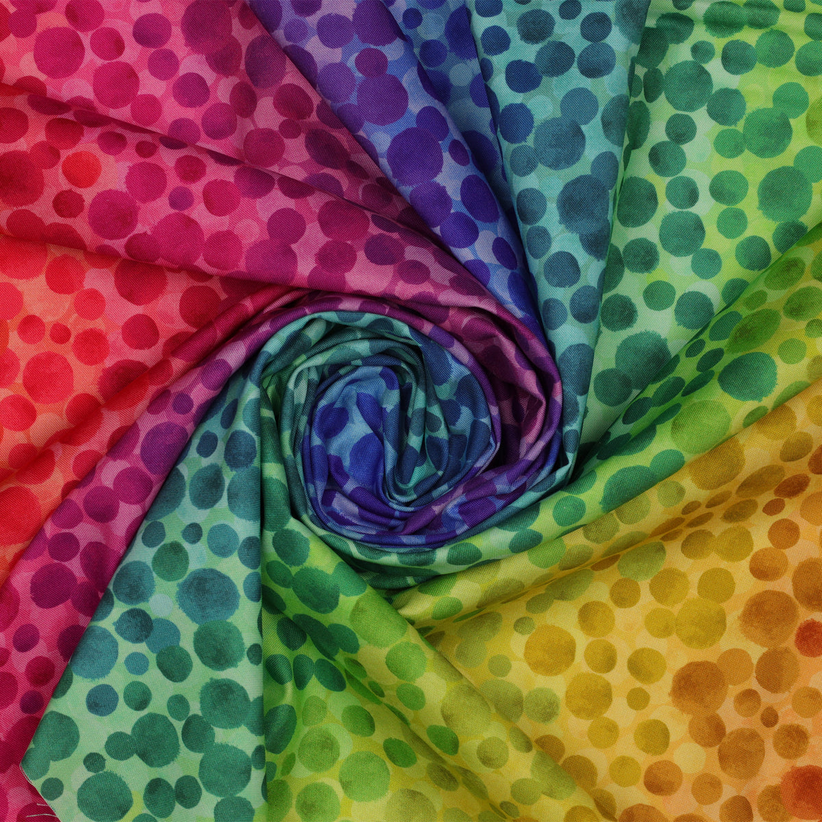 Bumbleberries Rainbow fabric arranged in a spiral, showcasing colorful dots transitioning through bold shades of red, pink, violet, blue, teal, green, yellow, and orange.