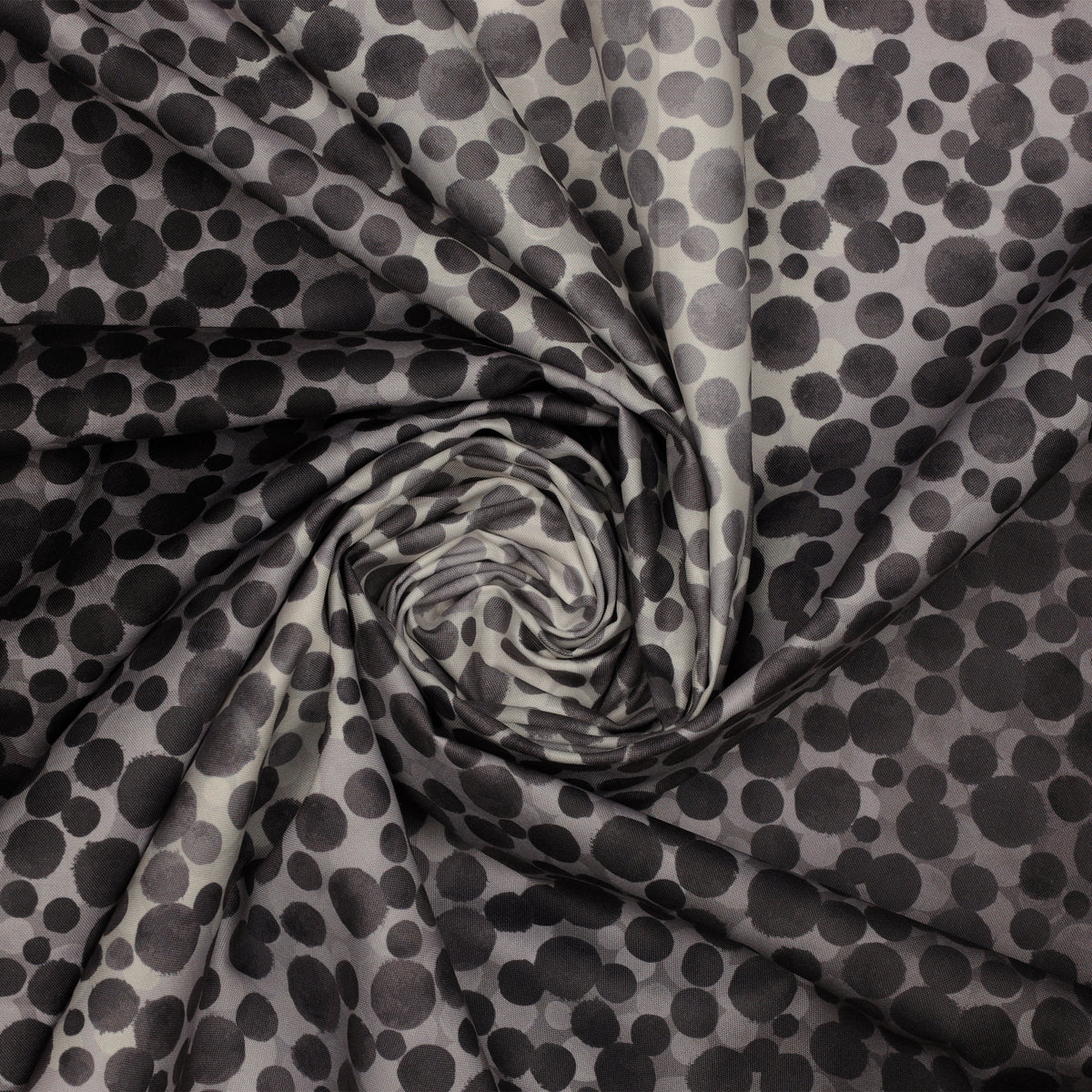 Bumbleberries Black to White fabric gathered in a spiral, showcasing irregular black and gray dots in varying sizes.