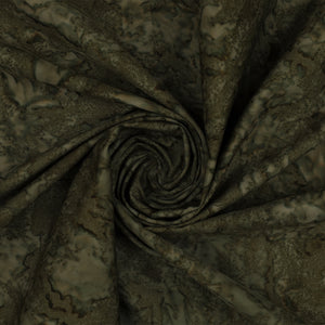 A close-up of draped fabric with an abstract marbled or mottled pattern in dark olive green, brown, and beige tones, arranged in a spiral fold.