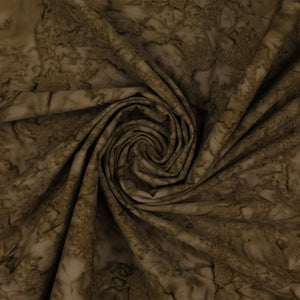 A close-up of draped fabric with a mottled, marbled pattern in earthy brown and beige tones, arranged in a spiral fold.