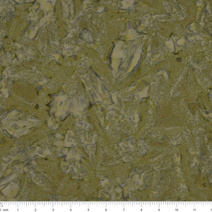 A close-up of fabric in muted olive green and beige tones, with a ruler scale visible along the bottom edge.