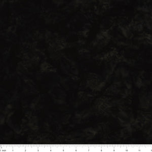 A close-up of a dark, mottled fabric texture with a white inch ruler along the bottom edge for scale.