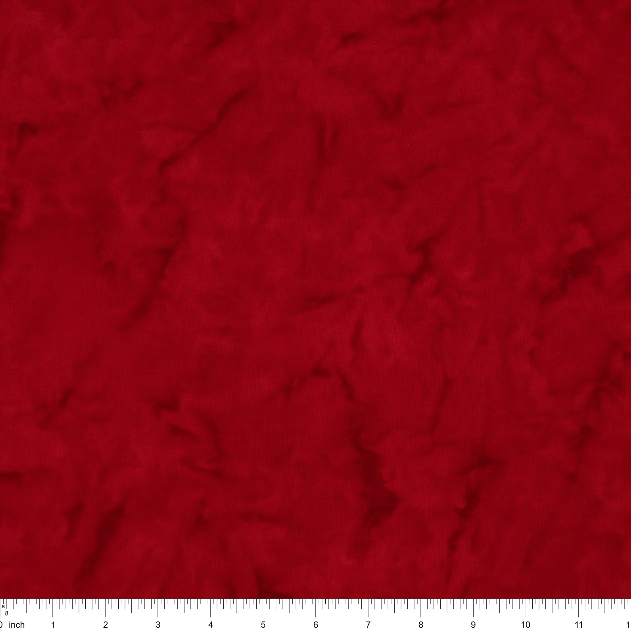 A close-up of a textured red fabric surface with a white ruler along the bottom edge for scale.