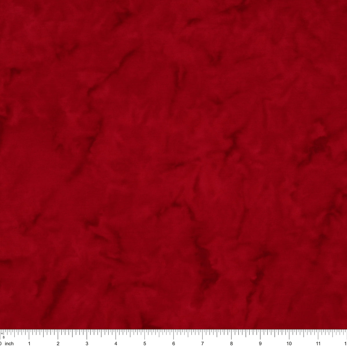 A close-up of a textured red fabric surface with a white ruler along the bottom edge for scale.
