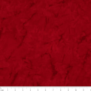 A close-up of a textured red fabric surface with a white ruler along the bottom edge for scale.