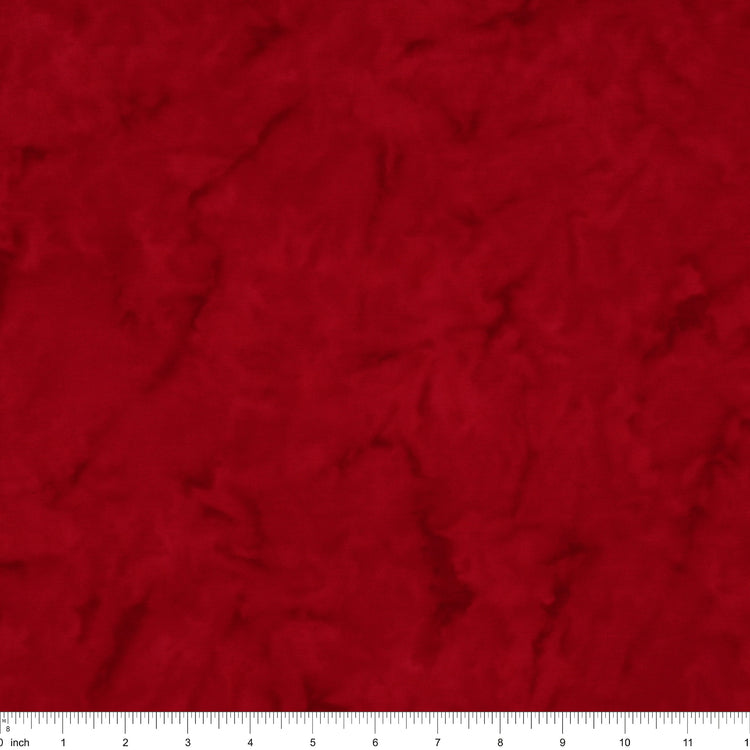 A close-up of a textured red fabric surface with a white ruler along the bottom edge for scale.