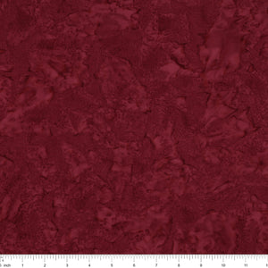 A close-up of a dark red marbled or textured material swatch with a ruler scale visible along the bottom edge.