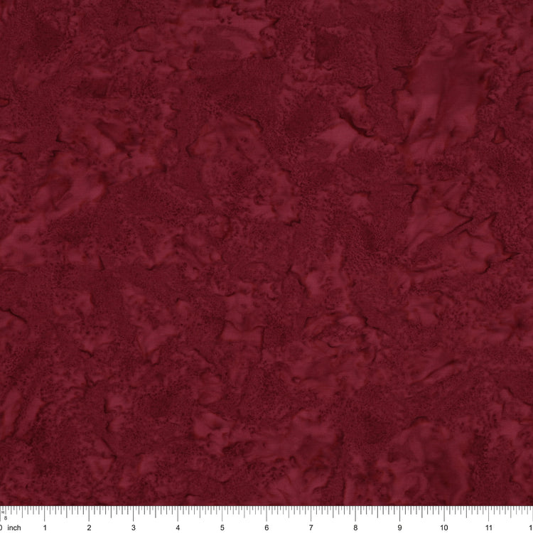 A close-up of a dark red marbled or textured material swatch with a ruler scale visible along the bottom edge.