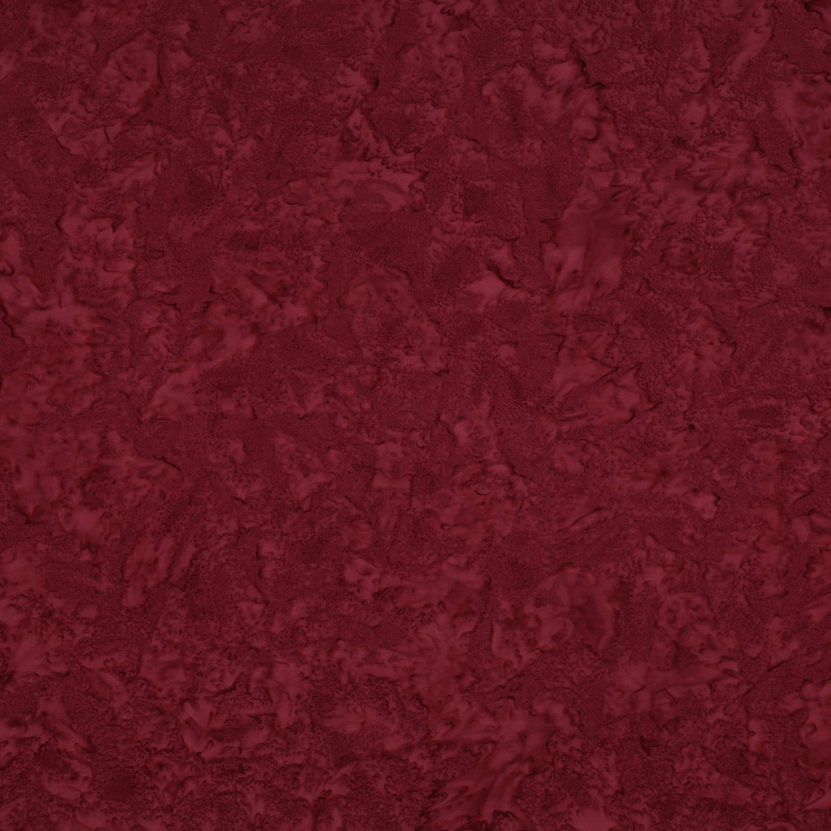 Sassy batik fabric with rich burgundy mottling and raspberry-red highlights.