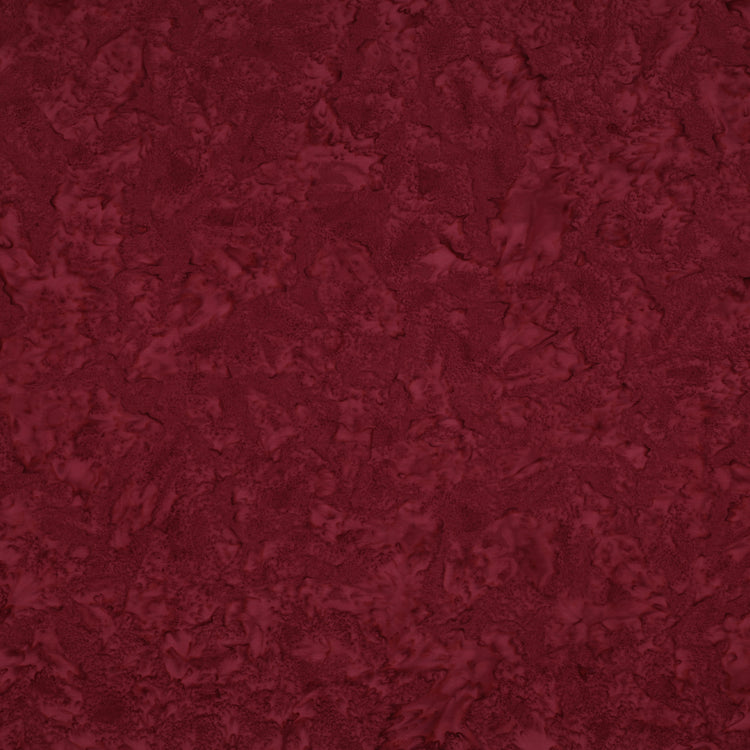 Sassy batik fabric with rich burgundy mottling and raspberry-red highlights.
