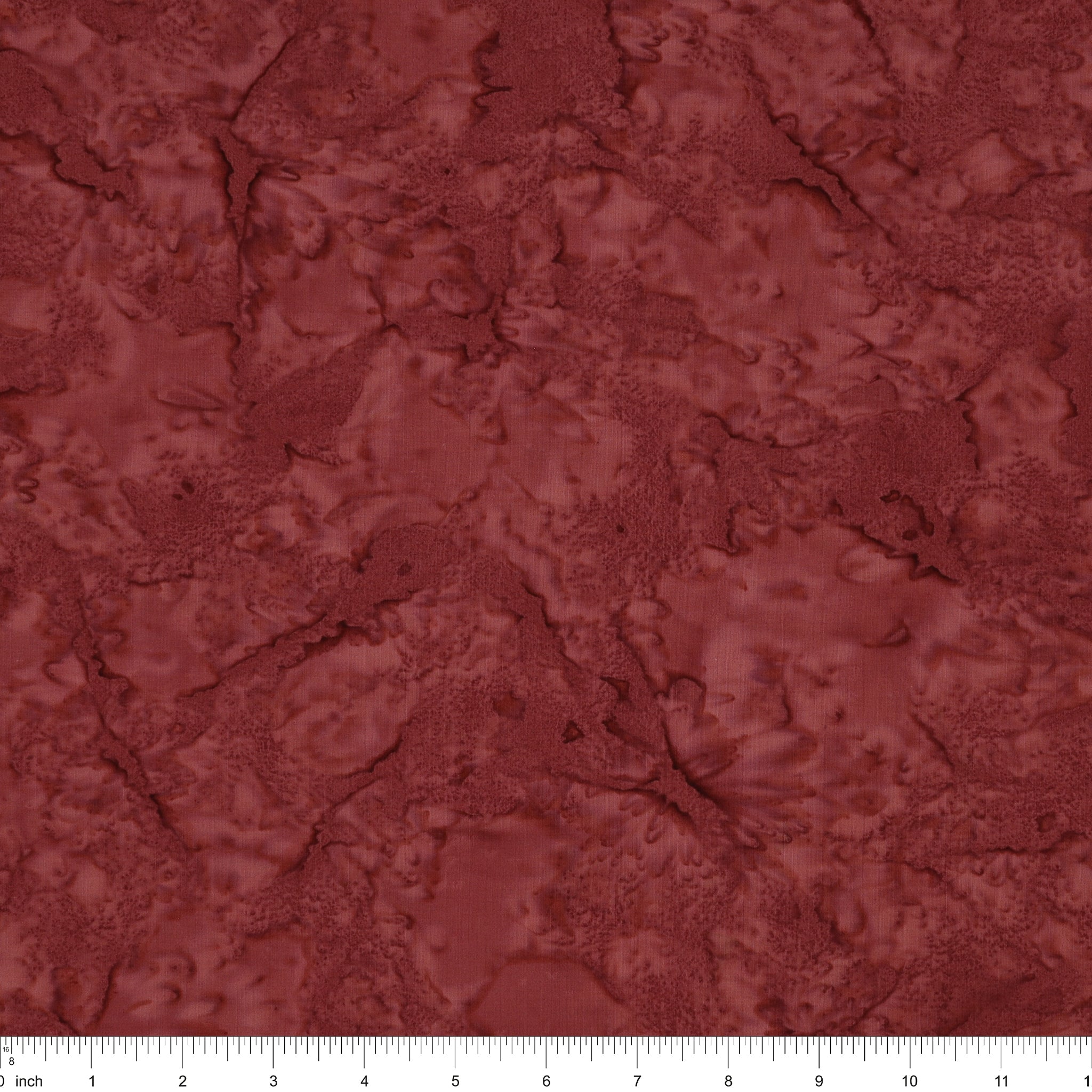 A close-up of a marbled fabric in a deep reddish-brown or burgundy shade, with a white ruler along the bottom edge showing scale.