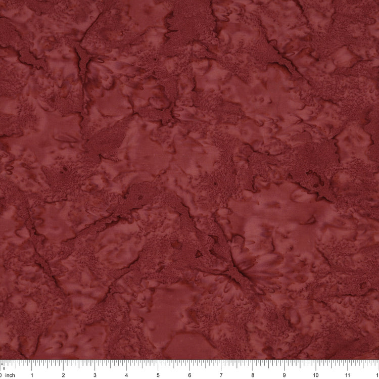 A close-up of a marbled fabric in a deep reddish-brown or burgundy shade, with a white ruler along the bottom edge showing scale.