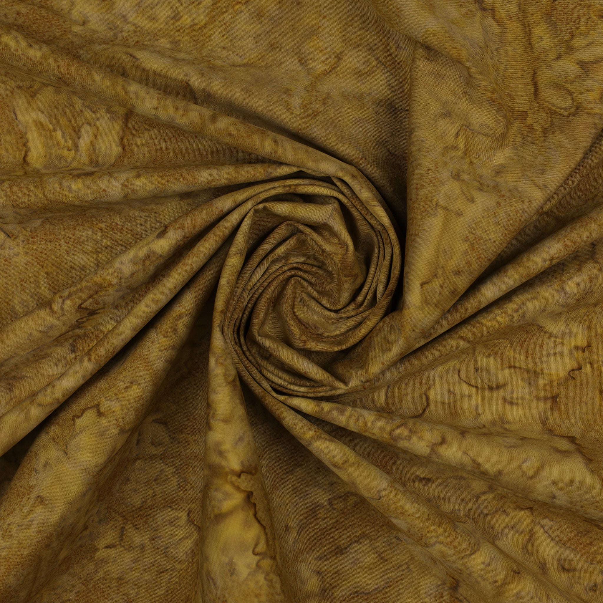 A close-up of draped fabric with a mottled, marbled pattern in warm golden brown, tan, and olive tones, arranged in a spiral fold.